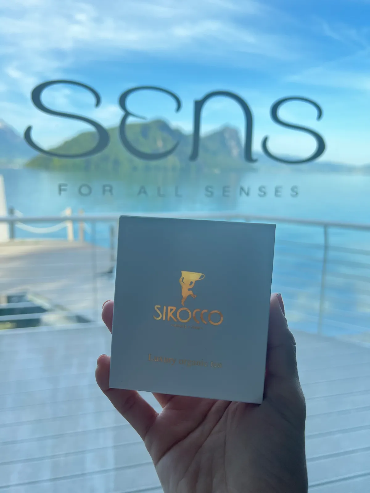 Teebox Luxury Organic Tea von Sirocco vor dem Schriftzug des Restaurants Sens am See